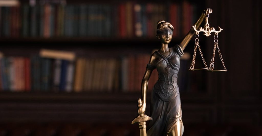 Lady Justice and gavel on a table in a classic law library setting.