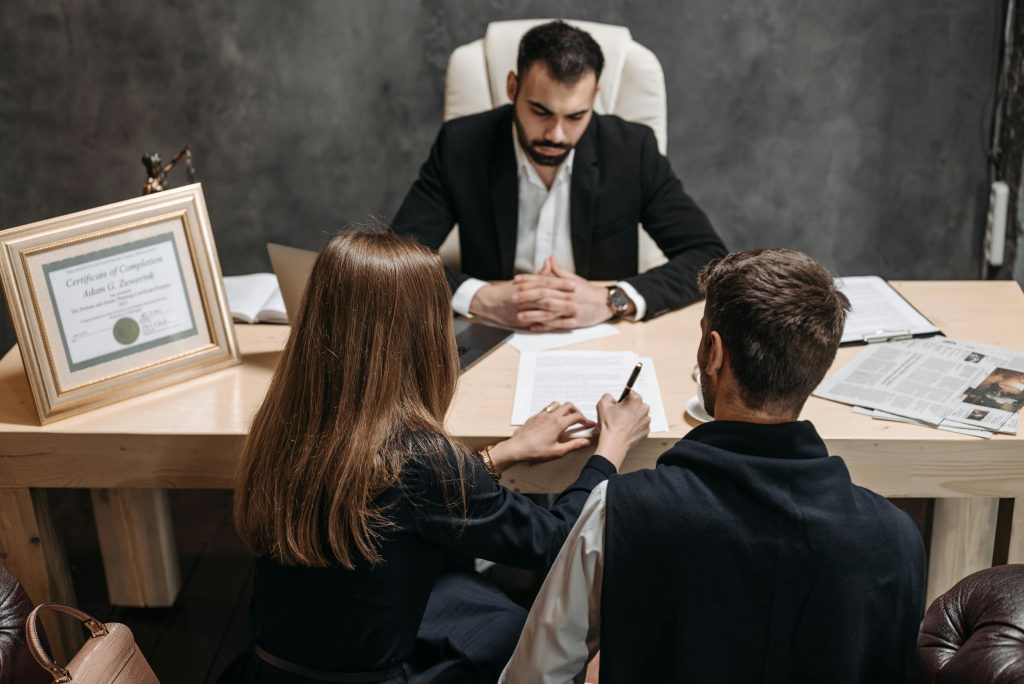 A lawyer discusses legal documents with clients in an office setting.